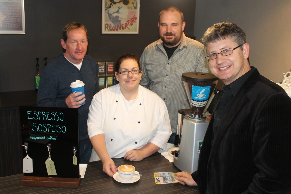 CDS worker John Mahoney, L'aquila owner Jenny Rossington and pastor Darryl Peters accept payment from Ewen Macpherson for the first suspended coffee. CDS worker John Mahoney, L'aquila owner Jenny Rossington and pastor Darryl Peters accept payment from Ewen Macpherson for the first suspended coffee.